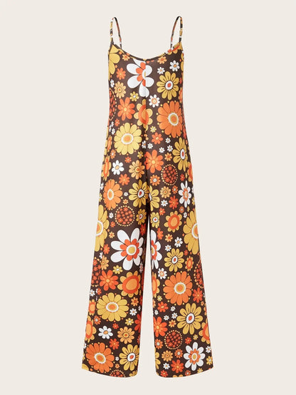 Woman wearing a loose floral print jumpsuit with thin straps.
