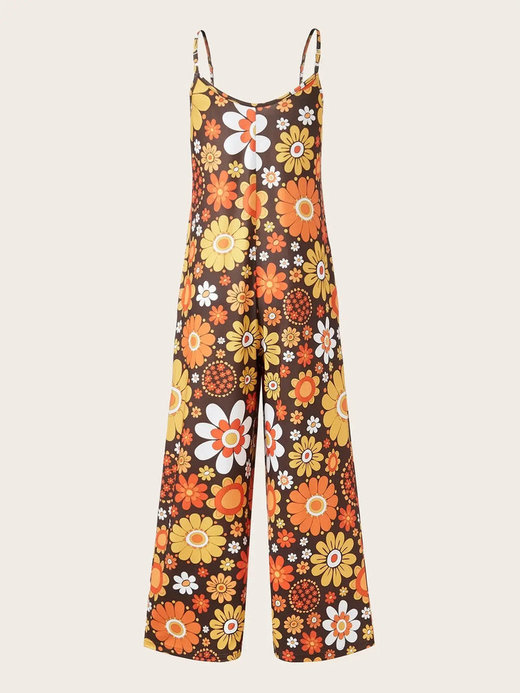 Woman wearing a loose floral print jumpsuit with thin straps.