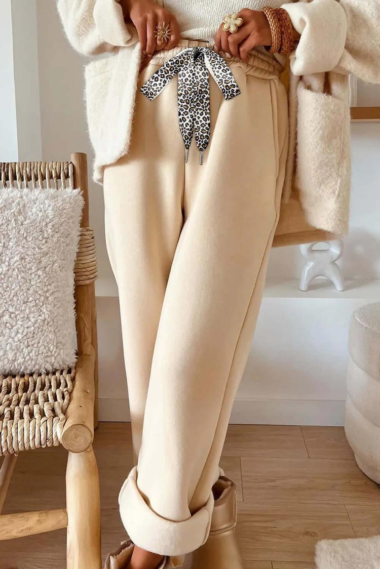 Cozy oatmeal sweater paired with stylish leopard pants, perfect for a fashionable and comfortable outfit.