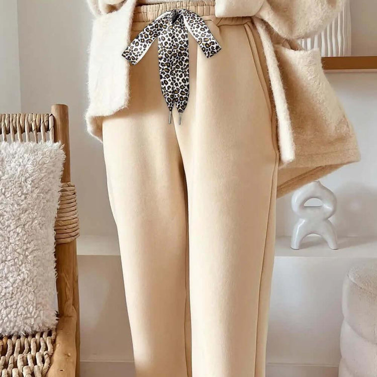 Cozy oatmeal sweater paired with stylish leopard pants, perfect for a fashionable and comfortable outfit.