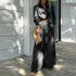 Womens plus size pant set featuring a crisscross top and wide-leg pants in black, styled for elegance and comfort.