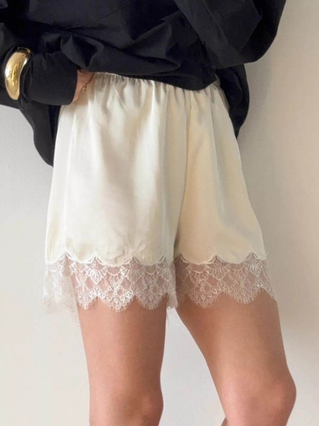 Elegant lace shorts showcasing intricate design and refined craftsmanship for sophisticated summer fashion.
