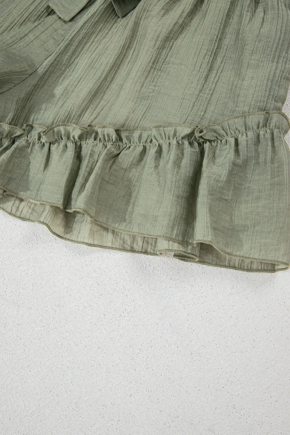 Tie waist shorts with elegant ruffle hem detail, perfect for a stylish and comfortable summer outfit.
