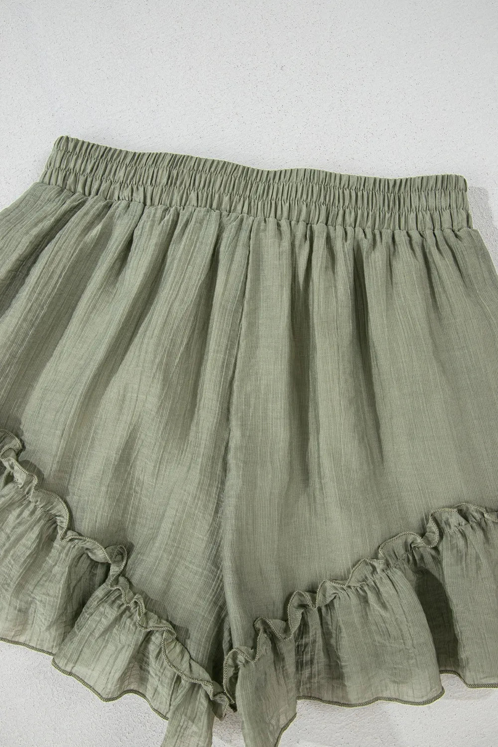 Tie waist shorts with elegant ruffle hem detail, perfect for a stylish and comfortable summer outfit.